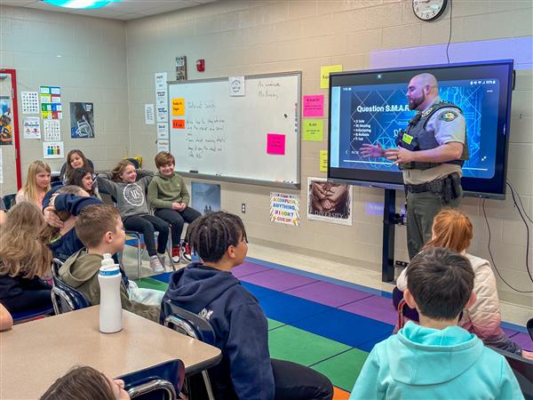 police officer talking to class of students